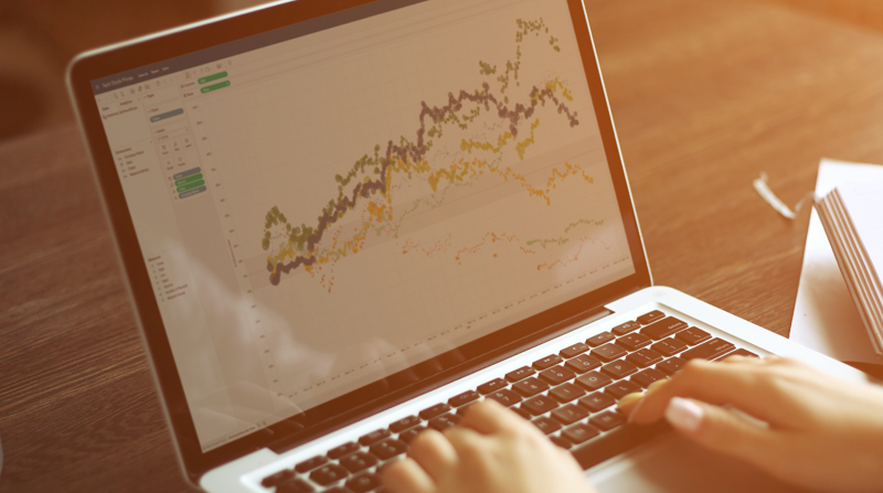 Visually explore data with Tableau's BI tools. (hands on computer with graphs on screen)